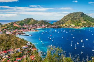 Vue panoramique sur la baie de Terre-de-Haut aux Saintes, avec de nombreux voiliers au mouillage et les reliefs de l’archipel.