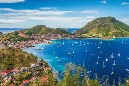 Vue panoramique sur la baie de Terre-de-Haut aux Saintes, avec de nombreux voiliers au mouillage et les reliefs de l’archipel.